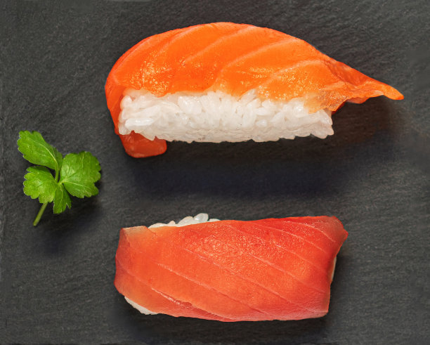 寿司套装米饭，三文鱼和虾在黑色石板背景俯视图。日本餐厅菜单。图片下载