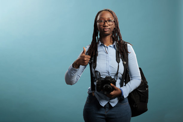站在蓝色背景上，快乐的摄影师给出了ok的手指手势图片下载