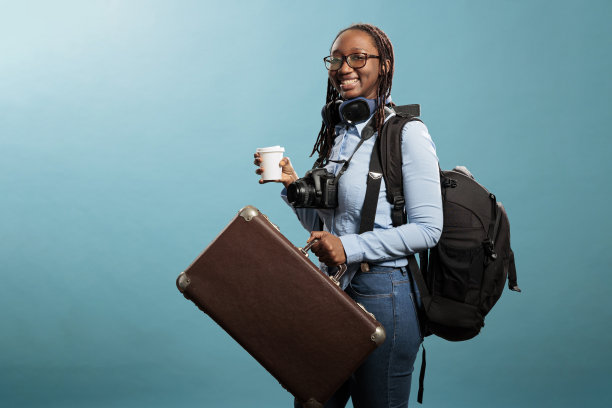 微笑的游客带着拍照设备和无线耳机等着去旅行图片下载