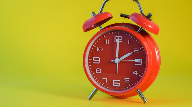 红色时钟孤立在黄色背景上图片下载