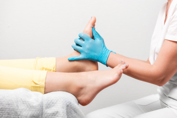 手足病医生为病人按摩脚部。腿部特写和戴着蓝色医疗手套的主人的手。足疗和足部学的概念图片下载