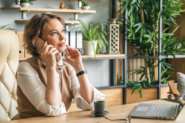 自信时尚成熟的中老年在职女性。工作中使用笔记本电脑，使用手机通话。总经理、首席执行官。年长的资深女商人，60多岁的西装女士，执行商业领袖。企业家的事业。会计在银行图片下载