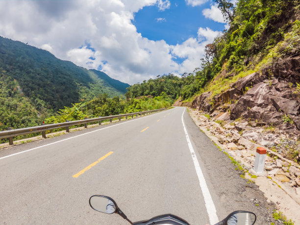 多云天气，骑摩托车的人在蜿蜒的道路上行驶。越南,提起图片下载
