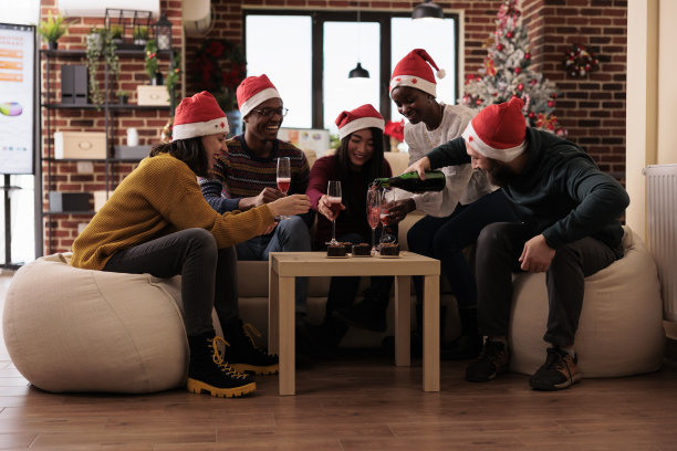 欢乐的人们在圣诞派对上喝着一瓶葡萄酒图片下载