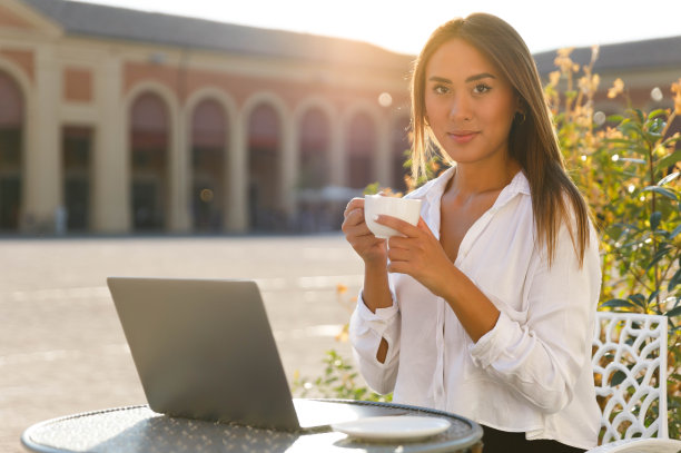 远程工作者在阳光明媚的城市广场享受咖啡休息图片下载