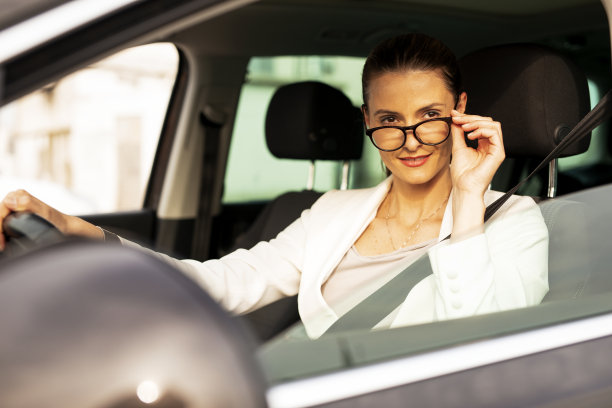漂亮的女商人开车。图片下载