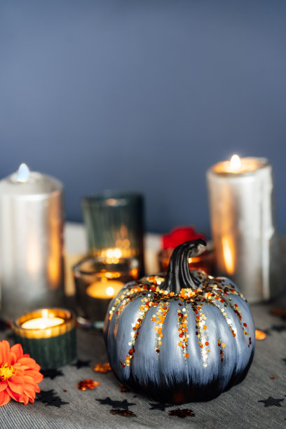 秋天温馨的心情构成家装。带亮片的灰色南瓜，燃烧的蜡烛，餐巾上放着新鲜的大丽花。秋天，hygge家居装饰。垂直的。有选择性的重点。副本的空间。图片下载