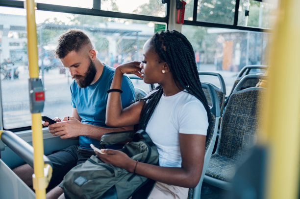 多种族朋友在城市乘坐公共汽车时用智能手机聊天图片下载
