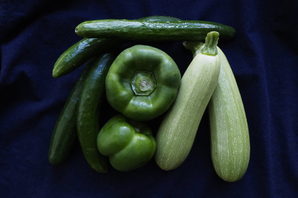 绿色甜椒，黄瓜和西葫芦在蓝色的背景图片下载