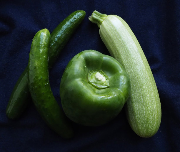 绿色甜椒，黄瓜和西葫芦在蓝色的背景图片下载