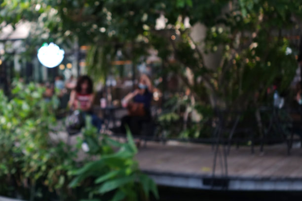 模糊抽象的背景户外咖啡馆或餐厅。户外咖啡馆，有桌椅。傍晚在现代露台上的街边咖啡馆。顾客们坐在咖啡馆外露台区域的桌子旁图片下载