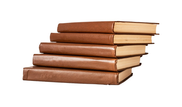 棕色封面的经典书籍堆在白底上。小说像楼梯一样堆积在一起。阅读,教育理念。图片下载