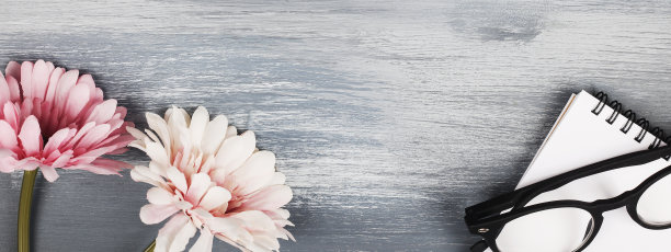 笔记本和玻璃，蓝色木制背景上的花。复制空间旗帜。女性工作空间，商业，研究，自由职业者和家庭办公室的概念。图片下载
