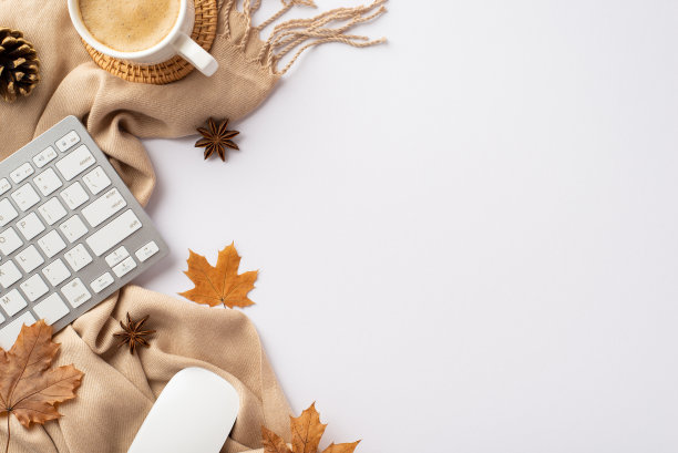 秋天的经营理念。俯视图照片的键盘，电脑，鼠标杯热饮藤服务垫黄色枫叶，松果，八角和围巾在孤立的白色背景与copyspace图片下载
