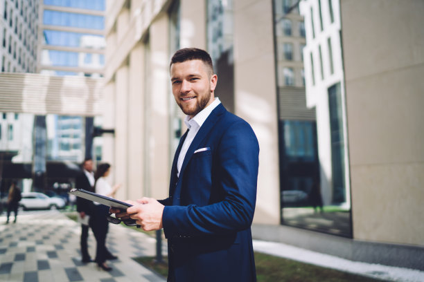 积极的男性企业家站在城市人行道上图片下载