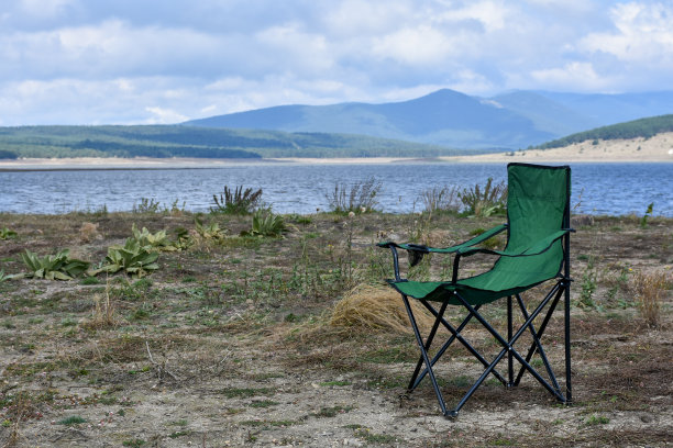 湖边的野营椅，以山和天空为背景图片下载
