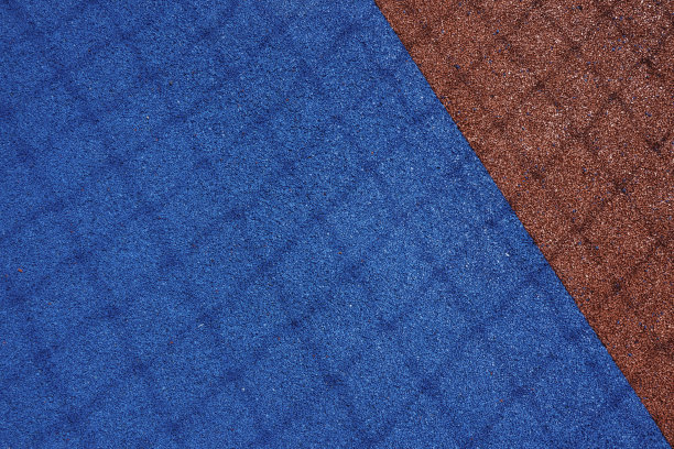 五彩缤纷的运动场背景。在阳光明媚的户外，俯视浅蓝色和红色的场地橡胶地面与足球球门网的阴影图片下载