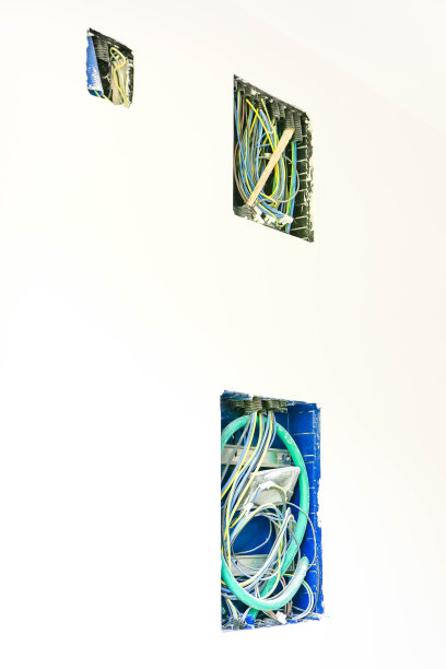 在郊区一栋在建房屋的墙上，有三个蓝色和绿色的空腔用于安装电力系统(电缆)图片下载