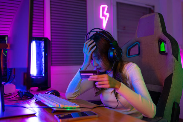用信用卡的概念充值在线游戏。亚洲女性在线电子竞技游戏玩家和电子竞技在线玩家，在家里玩带有灯光效果的在线电脑游戏，直播。游戏玩家和电子竞技游戏图片下载