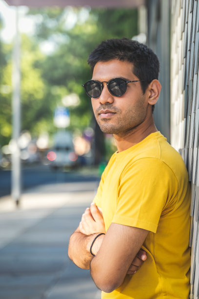 自信的西班牙裔男子靠在墙上图片下载