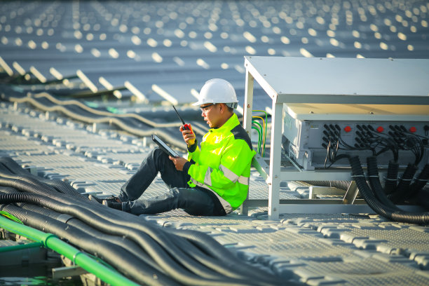 肖像的专业男子工程师工作检查在浮标上漂浮的太阳能电池板。电厂以水、可再生能源为主。工业电力的生态技术。图片下载
