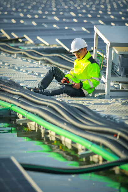 肖像的专业男子工程师工作检查在浮标上漂浮的太阳能电池板。电厂以水、可再生能源为主。工业电力的生态技术。图片下载