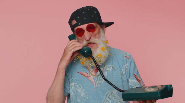 疯狂时髦的老年老人在80年代的老式有线电话上讲话，开玩笑，做鬼脸图片下载