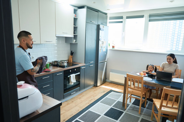 微笑的男人手里拿着厨房毛巾站在厨房橱柜图片下载