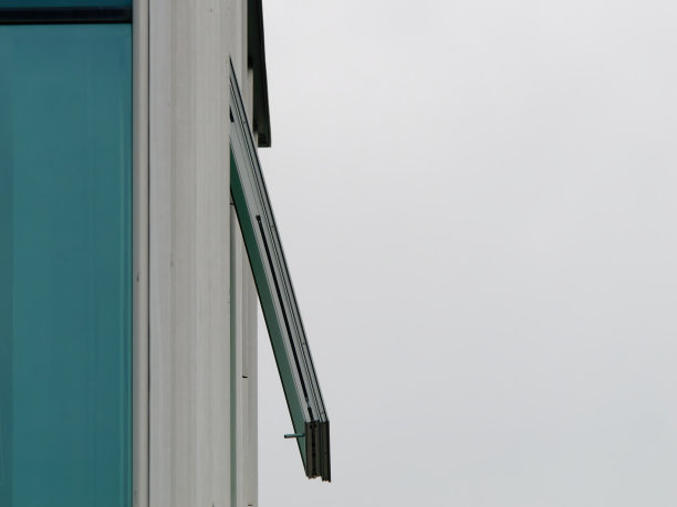 现代建筑的侧面图，一扇开着的窗户，背景是明亮的天空图片下载