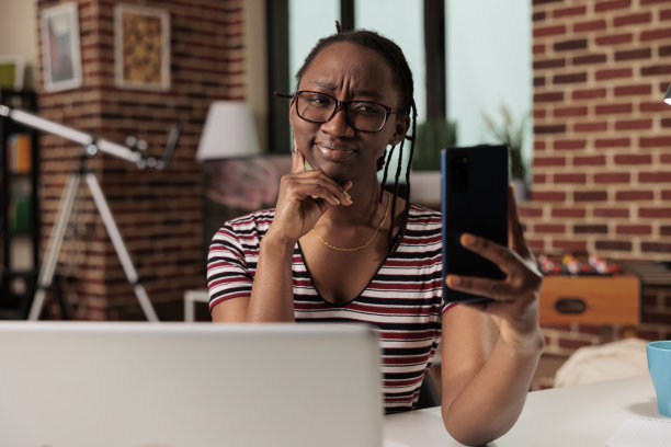 年轻的非洲裔美国女性在智能手机上自拍图片下载