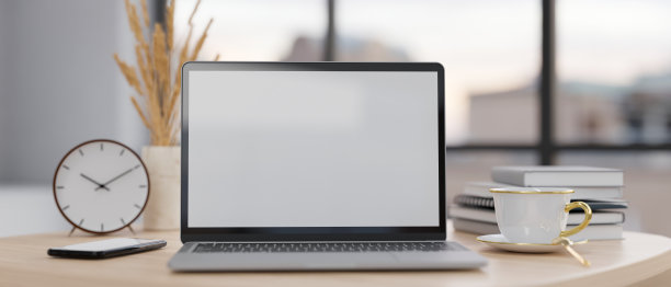 最小的工作空间与笔记本电脑模型，闹钟，智能手机，咖啡杯和书在木桌子上图片下载