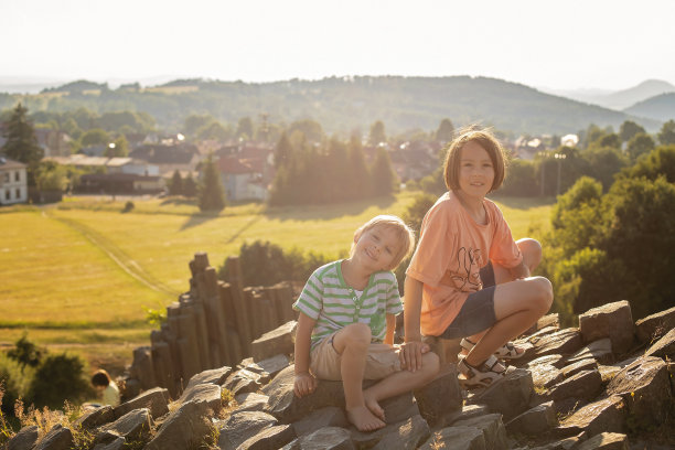 孩子们在一个玄武岩柱的多边形结构上攀爬，这是捷克共和国Kamenicky Senov附近的自然遗迹Panska skala。图片下载