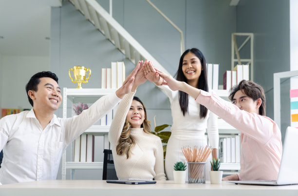 年轻的同事男同事和女同事在不经意的双手一起工作庆祝在工作空间的办公室，回到办公室和团队合作的概念图片下载