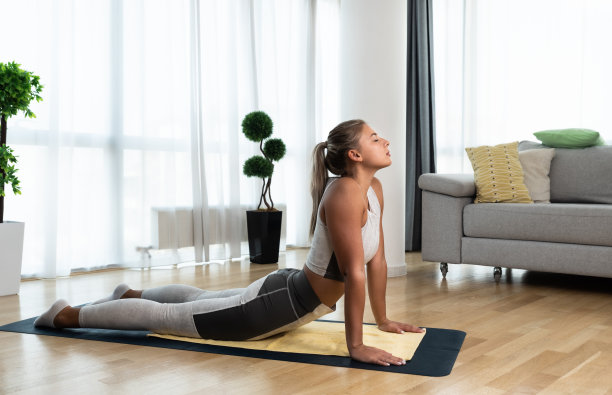 年轻女子车祸后在家进行康复锻炼。年轻女孩的恢复训练与瑜伽训练姿势拉伸肌肉。女性产后放松。图片下载