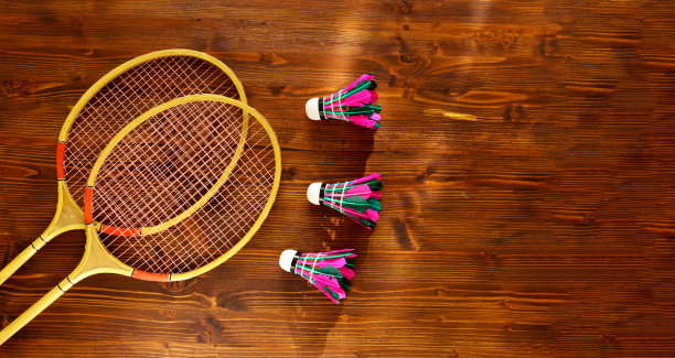 羽毛球球拍和毽子在木制背景顶视图空间的文字。羽毛球的概念图片下载