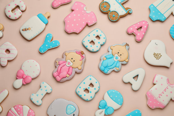 一套婴儿淋浴饼干在浅粉红色的背景，平躺图片下载