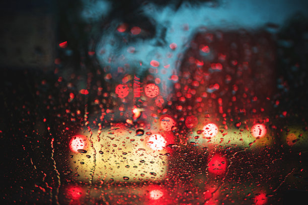 从车里看在雨中的城市道路上。图片下载