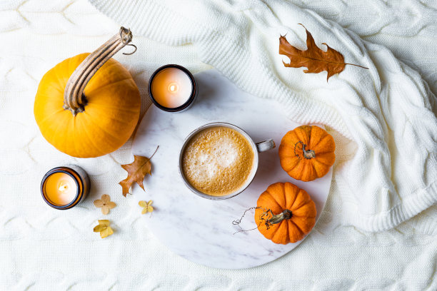秋季舒适的假日背景与杯咖啡，蜡烛，南瓜和羊毛针织格纹。暖暖的秋意平铺。早餐在床上图片下载