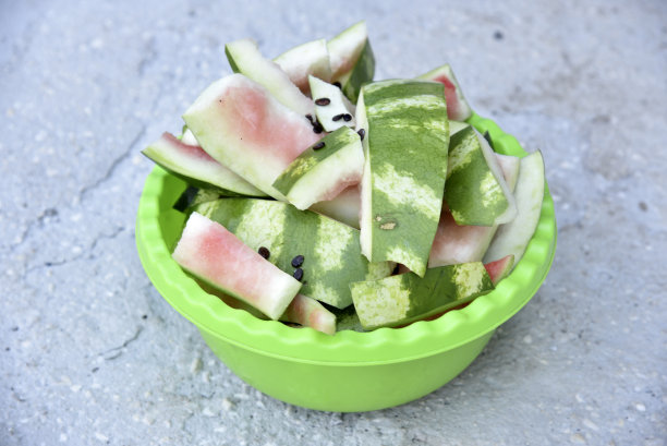 西瓜皮和剩菜放在绿色的盆里。菜篮子里的垃圾。饭后的剩饭剩菜。图片下载