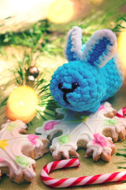 新年装饰。金色的灯光。圣诞贺卡和有趣的玩具兔子。新年快乐图片下载