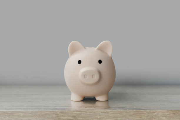 企业财务和投资节约资金。木桌上的储蓄罐，存钱理财的概念，商业、金融、投资、理财规划图片下载