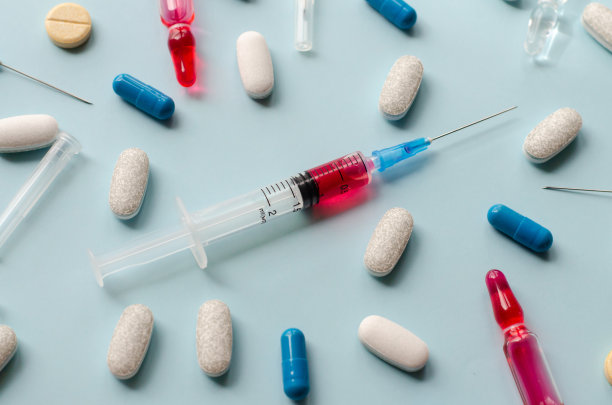 手术用品。注射用药物。抗生素安瓶。桌上放着五颜六色的药丸。感冒药。医生给病人打针。维生素。图片下载