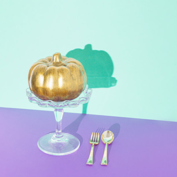 金色南瓜蛋糕架与金色勺子和叉子。美学的感恩节或万圣节组成极简风格，潮流的粉彩颜色。图片下载