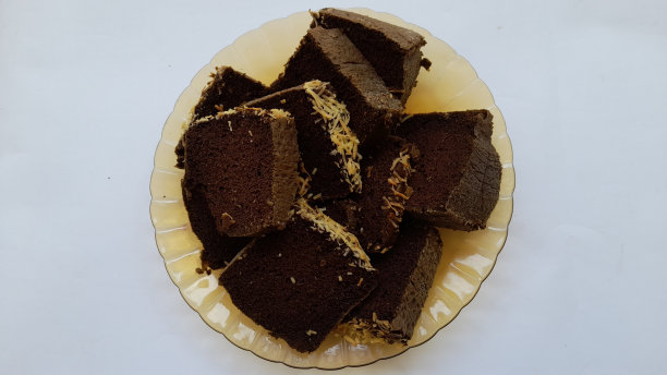 在白色背景上从上面看盘子上的黑色糯米海绵蛋糕图片下载