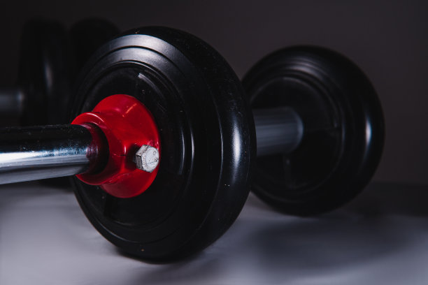 高质量的摄影。靠近一个孤立的黑色背景上的黑色哑铃。健身房买的哑铃。图片下载