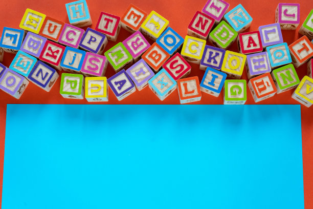 木制的彩色方块与字母在橙色的背景。学前教育，阅读，字母表。回归学校理念图片下载
