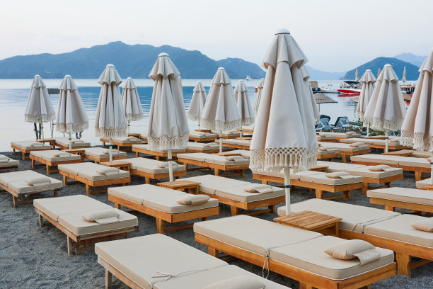 在马尔马里斯湾的海滩上，舒适的阳光躺椅和带靠垫的雨伞。图片下载