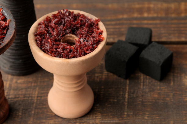 棕色木桌上放着水烟用的陶碗。附件为水烟。特写镜头图片下载