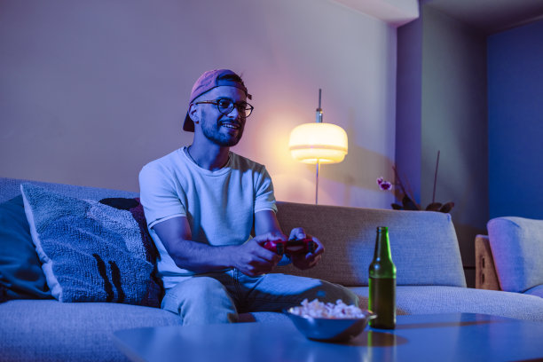 这个年轻人正在玩电子游戏享受夜晚的时光图片下载