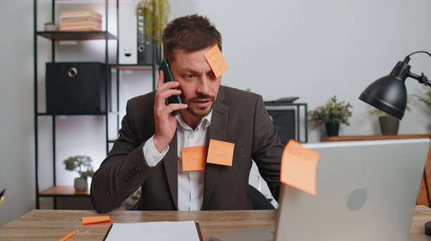 疲惫难过精疲力竭的商人在办公室用笔记本电脑完成许多贴纸任务，恐慌发作图片下载